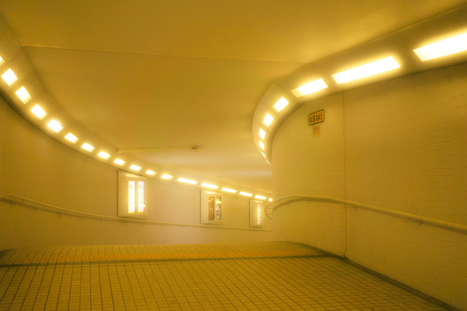 A yellow lit tunnel with windows.